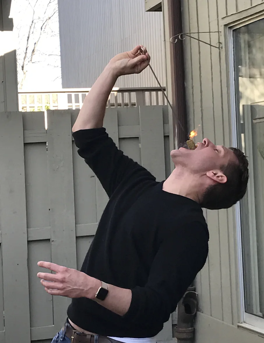 Close-up of Jacob Abernethy performing a fire-eating routine outdoors